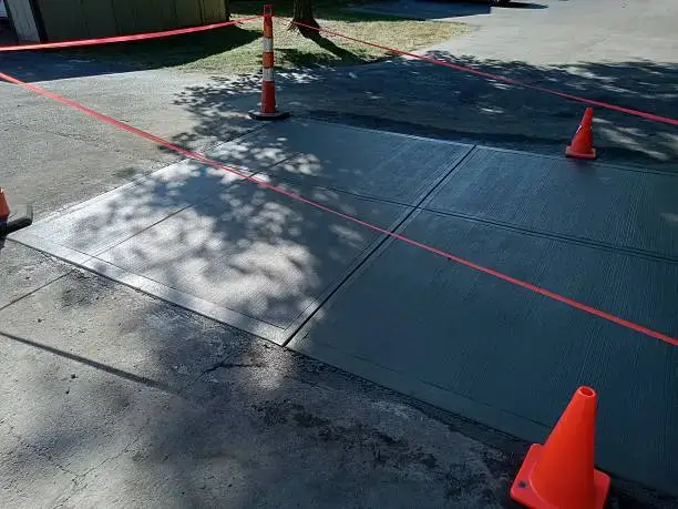 Concrete pavement replacement with orange cones surrounding it